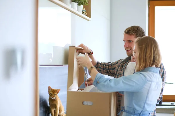 Pareja joven que lleva la caja de cartón grande en el nuevo hogar.Mudanza de la casa. Pareja joven — Foto de Stock