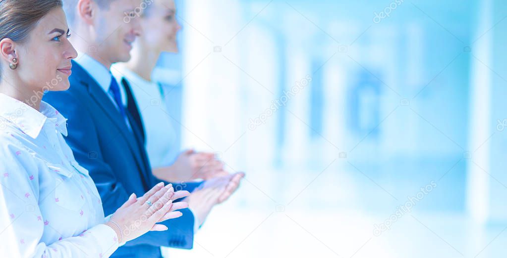Smiling business people applauding a good presentation in the office