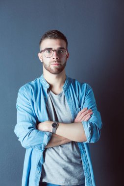 Mutlu bir casual adam ayakta karanlık bir arka plan üzerinde izole portresi. Yakışıklı erkek poz.