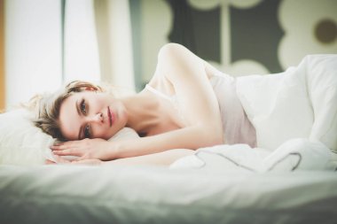 Güzel bir kadın yatağında uzanıyor..
