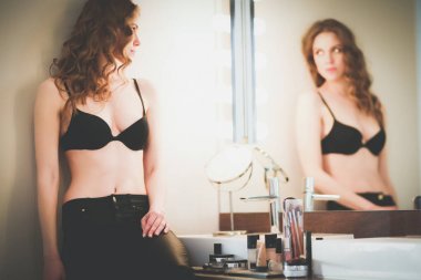 Genç kadın kendini banyo ayna arıyor.