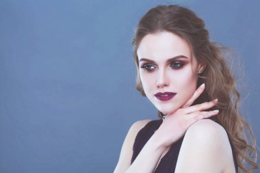 Güzel genç kadın yüz portresi. Gri arka plan üzerinde izole.