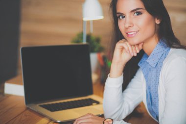 Masada oturan genç bir kadın..