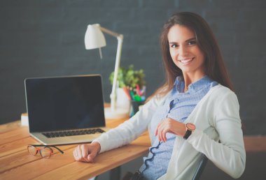 Masada oturan genç bir kadın..
