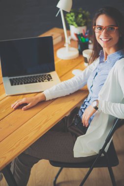 Masada oturan genç bir kadın..
