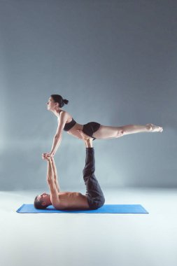 Genç çift Acro yoga mat Studio birlikte uygulamak. Acroyoga. Çift yoga. Ortak yoga.