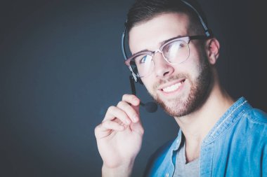 Mikrofon ile genç erkek portresi. Çağrı Merkezi asistanı. Resepsiyon alt yardımcı olmak.