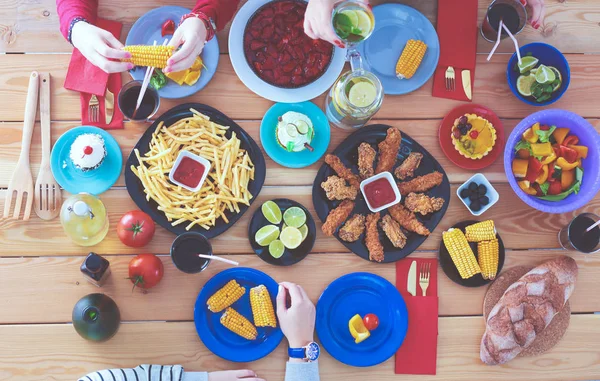 İnsanlar içecekler yemek masasında otururken. Masaya yiyecek. Masaya yiyecek. İnsanlar hızlı yemek yemek.