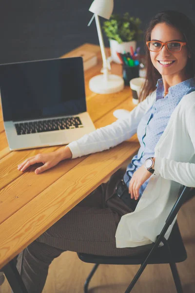 Masada oturan genç bir kadın..