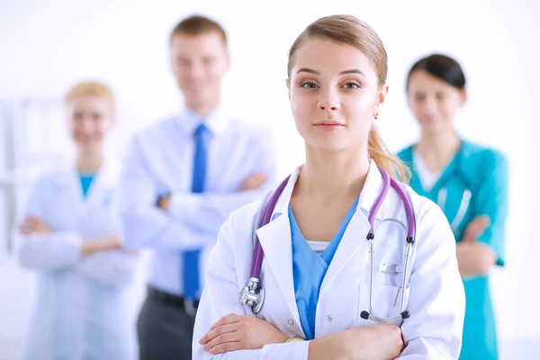 Attractive female doctor with medical stethoscope in front of medical group — Stock Photo, Image
