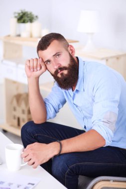 Genç işadamı koltukta oturuyor.