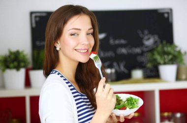 Salata yemek ve karışık salata tutan genç kadın