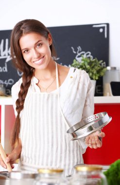 Mutfakta ahşap kaşıkla yemek pişiren kadın