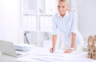 Ofisinde planları olan kadın mimarın portresi.