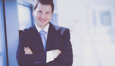 Ofisteki pencerenin yanında duran işadamının portresi