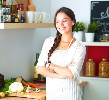 Mutfakta masanın yanında duran genç bir kadın.