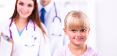 Kadın doktor ameliyatta steteskopla çocuğu muayene ediyor.