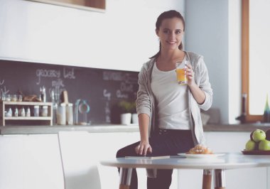 Mutfakta masada oturan genç kadın.