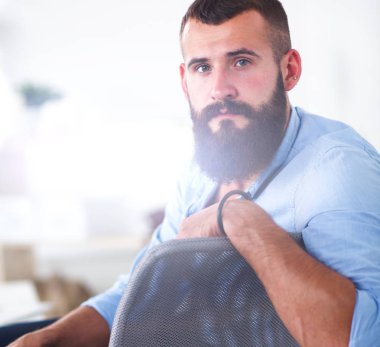 Genç işadamı koltukta oturuyor.