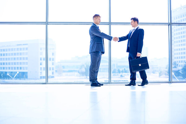 Изображение двух успешных бизнесменов, пожимающих друг другу руки