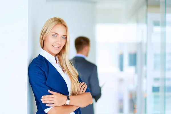 Portret van jonge zakenvrouw in functie met collega 's op de achtergrond — Stockfoto