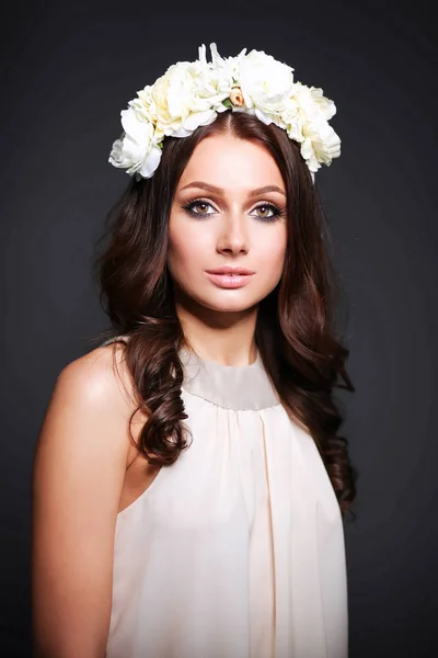 Retrato de uma mulher bonita com flores no cabelo — Fotografia de Stock