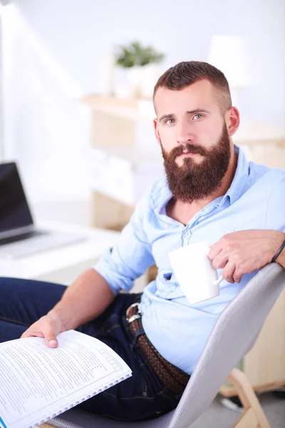 Young businessman sitting on chair in office — Stock Photo, Image