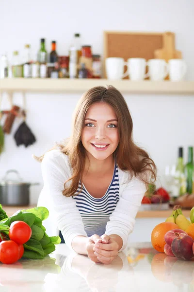 Jonge vrouw in de buurt van bureau in de keuken — Stockfoto