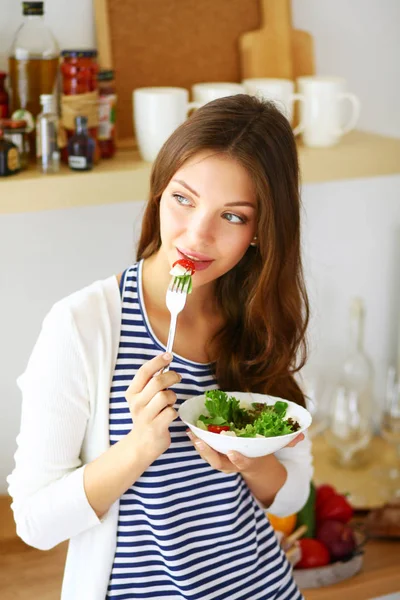 Salata yemek ve karışık salata tutan genç kadın