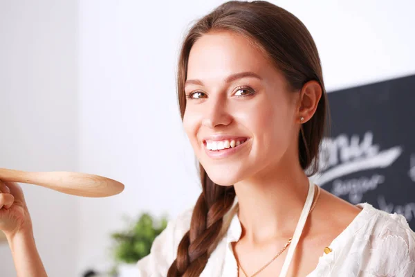 Mujer cocinera en cocina con cuchara de madera —  Fotos de Stock