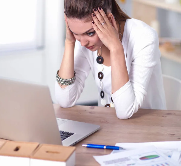 Betonade affärskvinna sitter vid skrivbord — Stockfoto