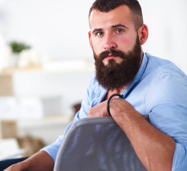 Genç işadamı koltukta oturuyor.