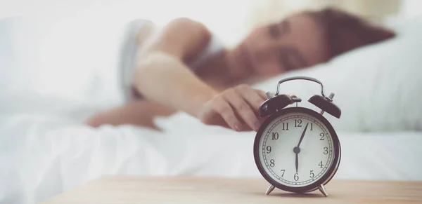 Ung sovande kvinna och väckarklocka i sovrummet hemma — Stockfoto