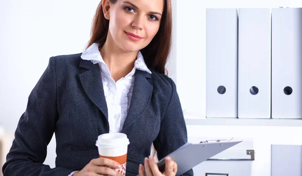 Atraktivní mladá podnikatelka stojící u stolu se složkou v kanceláři — Stock fotografie