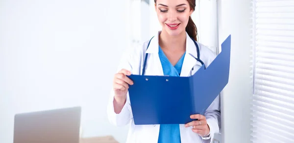 Young woman is standing in the near window with folder — Stock Photo, Image