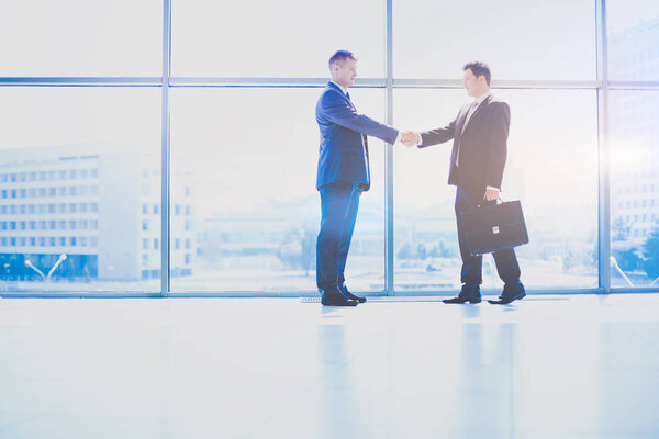 Изображение двух успешных бизнесменов, пожимающих друг другу руки