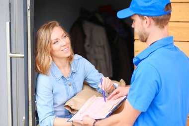 Mavi üniformalı gülümseyen kurye servis konseptine paket kutusu teslim eden teslimatçı. Mavi üniformalı gülümseyen teslimatçı.