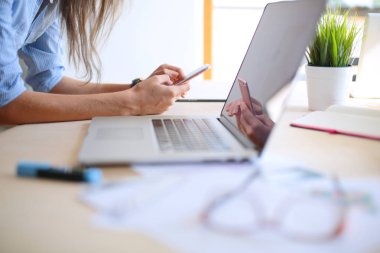 Ofis masasında oturan ve cep telefonuyla konuşan genç ve güzel bir iş kadını. İş kadını