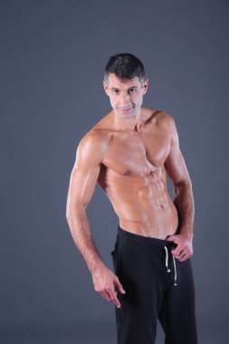 kaslı adam. Kaslı adam kas gösterilen gri arka plan üzerinde. Fitness Eğitmeni. Fitness profesyonel. Egzersiz. Mens fitness.