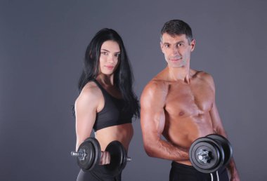 Atletik erkek ve kadın salak-bells ile. Kişisel fitness eğitmeni. Kişisel eğitim. Ağırlık çalışması. Egzersiz.