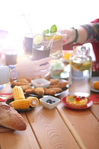 Draufsicht auf eine Gruppe von Menschen beim gemeinsamen Abendessen, während sie am Holztisch sitzen. Essen auf dem Tisch. Menschen essen Fast Food. — Stockfoto