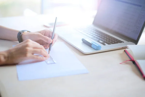 Young woman sitting at the desk with instruments, plan and laptop. Young woman — Stock Photo, Image