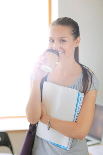 Retrato de una joven estudiante sosteniendo libros de ejercicios. Estudiante mujer —  Fotos de Stock