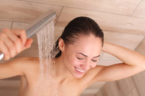 Junge schöne Frau unter der Dusche im Badezimmer. — Stockfoto