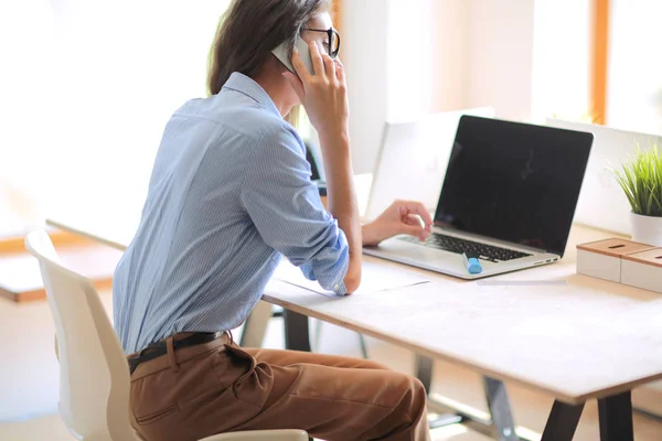 Giovane donna seduta al tavolo dell'ufficio con computer portatile. Giovane donna. Portatile — Foto Stock