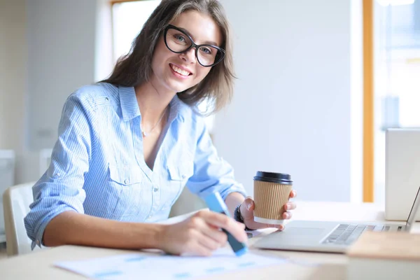 Jovem mulher sentada na mesa do escritório, olhando para a tela do computador portátil. Jovem mulher — Fotografia de Stock