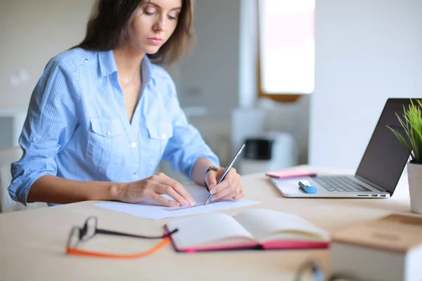 Jeune femme assise à la table de bureau avec ordinateur portable. Jeune femme. Ordinateur portable — Photo