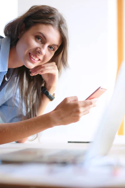 Mooie jonge zakenvrouw die aan het bureau zit en met haar mobiel praat. Zakelijke vrouw — Stockfoto