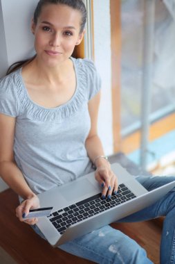Evde bir dizüstü bilgisayar kullanan genç güzel kadın. Genç güzel kadın.