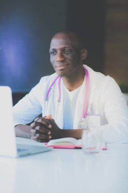 Masada dizüstü bilgisayarla çalışan genç bir Afrikalı doktor. Doktor bey. İşyeri